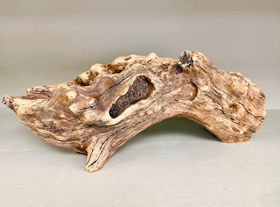 Side view of resin driftwood log planter on neutral background